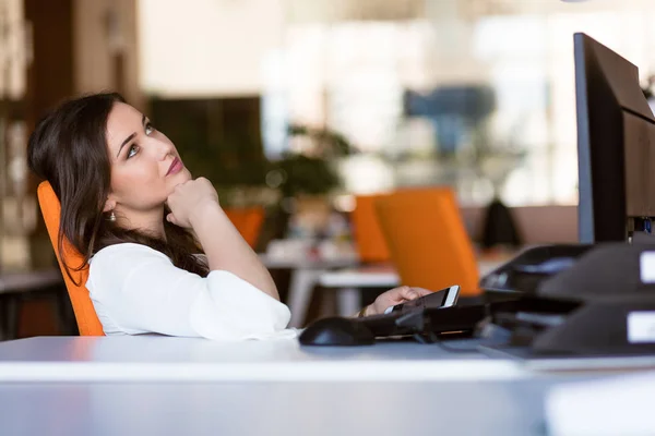 Feliz pensativa mujer de negocios planeando y mirando hacia los lados en la oficina —  Fotos de Stock