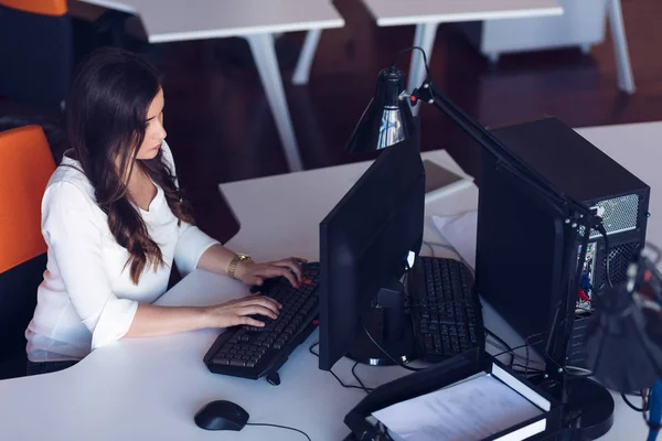 集中的中年妇女在她的计算机上工作。创业办公室背景 — 图库照片
