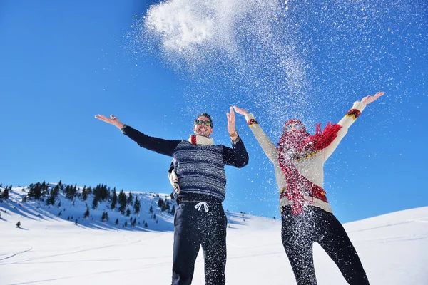Kaygısız mutlu genç çift karda birlikte eğleniyor.
