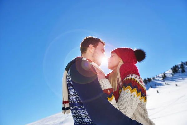 Una pareja amorosa abrazándose en el parque de invierno. Pusieron gorras y bufandas de colores. . — Foto de Stock
