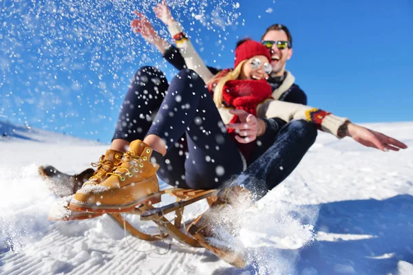 Kızak ve güneşli kış gününde zevk genç Çift