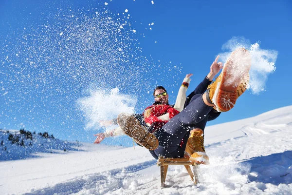 Jong (echt) paar rodelen en genieten op een zonnige winterdag — Stockfoto