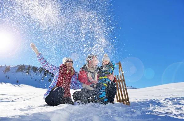 happy young family playing in fresh snow at beautiful sunny winter day outdoor in nature