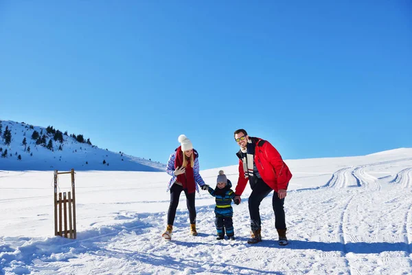 güzel güneşli kış günü doğada açık taze karda oynarken mutlu genç aile