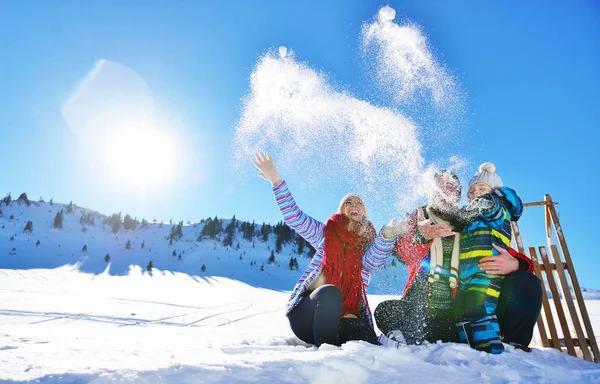 幸福年轻的家庭，在新鲜的雪打美丽晴朗的冬日户外性质 — 图库照片