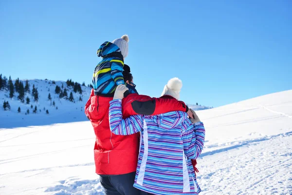 Feliz familia joven jugando en nieve fresca en hermoso día de invierno soleado al aire libre en la naturaleza — Foto de Stock