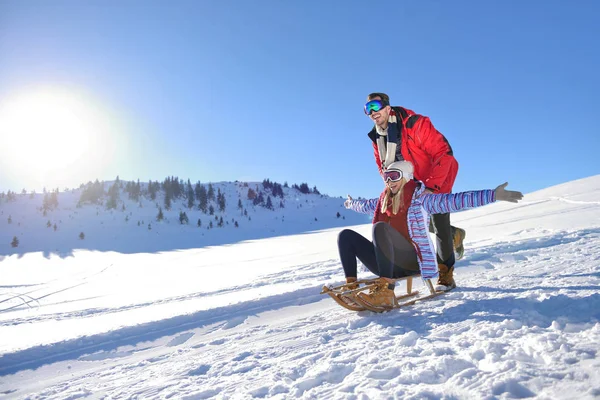Kızak ve güneşli kış gününde zevk genç Çift