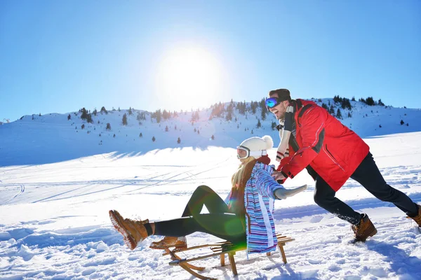 Kızak ve güneşli kış gününde zevk genç Çift