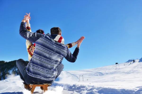 Casal jovem Sledding e desfrutar no dia ensolarado de inverno — Fotografia de Stock