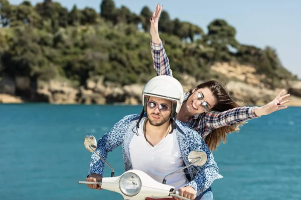 Pareja joven montando en un scooter — Foto de Stock