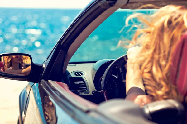 Νεαρή γυναίκα στο αυτοκίνητο κοντά στον ωκεανό — Φωτογραφία Αρχείου