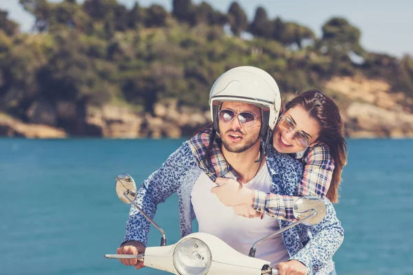 Junges Paar auf einem Motorroller unterwegs — Stockfoto