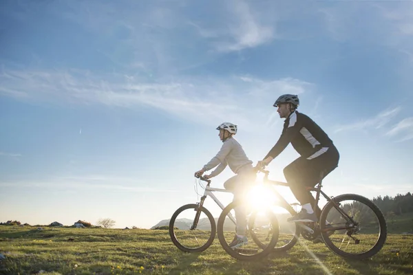 Feliz mountain bike pareja al aire libre divertirse juntos en un verano por la tarde —  Fotos de Stock