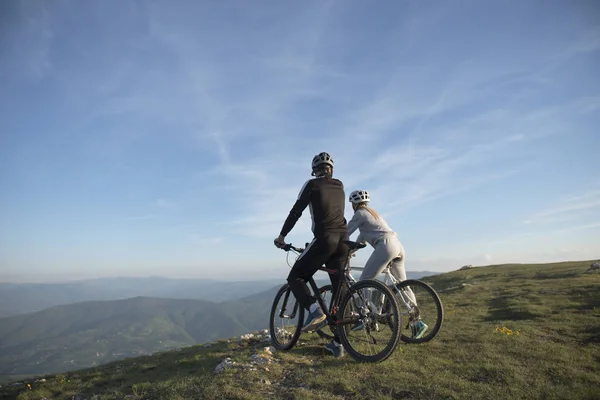 Couple of cyclists on hill — Stock Photo, Image