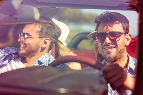Gruppe fröhlicher junger Freunde fährt Auto und lächelt im Sommer — Stockfoto