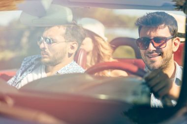 Arabayı ve yazları gülümseyen neşeli genç arkadaş grubu