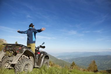 Adam Atv Quad Bisiklet dağlar yolda.