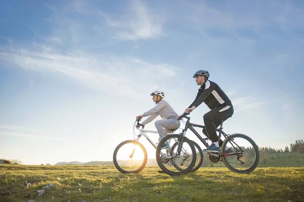 Mountainbike ευτυχισμένο ζευγάρι σε εξωτερικούς χώρους να διασκεδάσουμε όλοι μαζί σε ένα απόγευμα του καλοκαιριού — Φωτογραφία Αρχείου