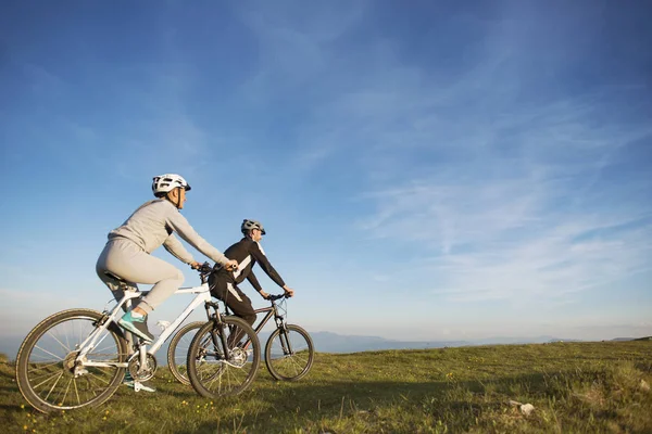 Feliz mountain bike pareja al aire libre divertirse juntos en un verano por la tarde —  Fotos de Stock