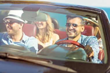 Arabayı ve yazları gülümseyen neşeli genç arkadaş grubu