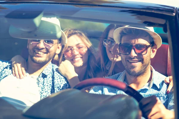 Grupp av glada unga vänner kör bil och leende på sommaren — Stockfoto