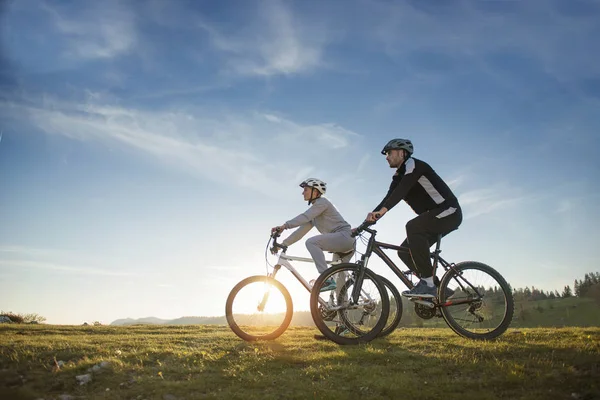 Mountainbike ευτυχισμένο ζευγάρι σε εξωτερικούς χώρους να διασκεδάσουμε όλοι μαζί σε ένα απόγευμα του καλοκαιριού — Φωτογραφία Αρχείου
