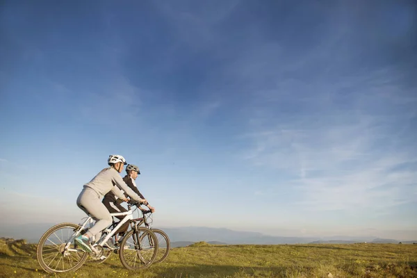 Couple of cyclists on hill — Stock Photo, Image