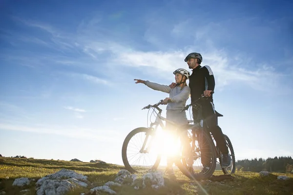 Couple of cyclists on meadow — Stock Photo, Image