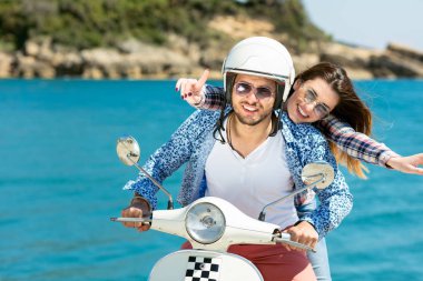 Aşk ve zevk sahip eğlenceli bir scooter üzerinde güzel doğada sürme güzel genç Çift