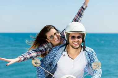 Aşk ve zevk sahip eğlenceli bir scooter üzerinde güzel doğada sürme güzel genç Çift