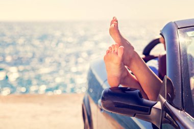 Kız tonda gökyüzü arka plan mavi Cabriolet eğleniyor. Yaz tatil ve seyahat kavramı