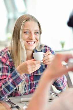 Genç çift - erkek ve kadın - cam cephe önünde bir kafede kahve içme