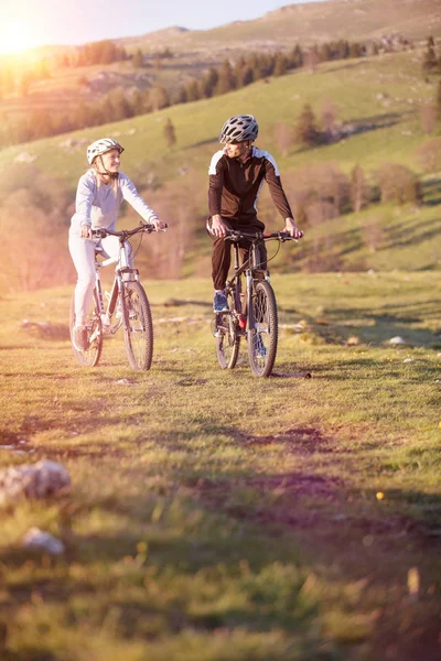 Feliz mountain bike pareja al aire libre divertirse juntos en un verano por la tarde —  Fotos de Stock