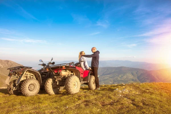 Vista trasera de la pareja joven cerca de atv. El hombre está mostrando algo en la distancia a su novia . —  Fotos de Stock