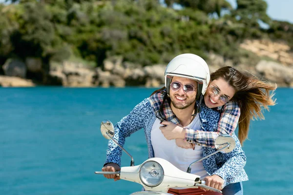 Schönes junges verliebtes Paar genießt und hat Spaß auf einem Motorroller in einer wunderschönen Natur — Stockfoto