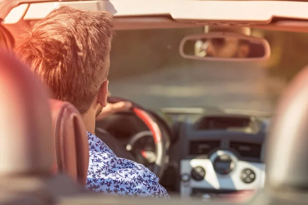 Pareja joven conduciendo a lo largo de Country Road en coche abierto — Foto de Stock