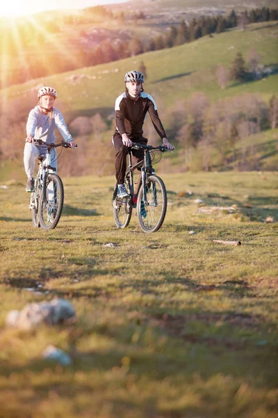 Feliz mountain bike pareja al aire libre divertirse juntos en un verano por la tarde —  Fotos de Stock