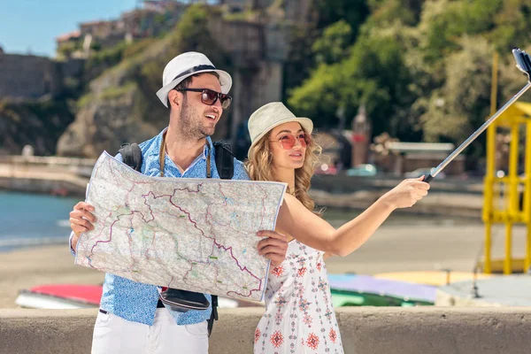 Giovani amici bella coppia turistica e prendendo selfie bastone foto insieme in città felice nella giornata di sole — Foto Stock