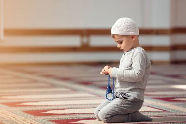 Müslüman çocuk camide dua ediyor, küçük çocuk Tanrı'ya, barış ve sevgi Ramazan kutsal ay içinde dua ediyor.