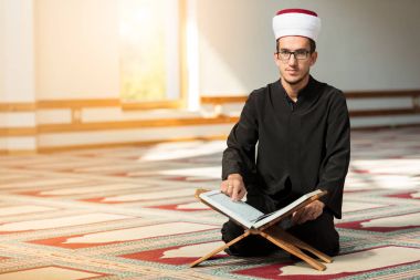 Dindar Müslüman adam caminin içinde dua ediyor.