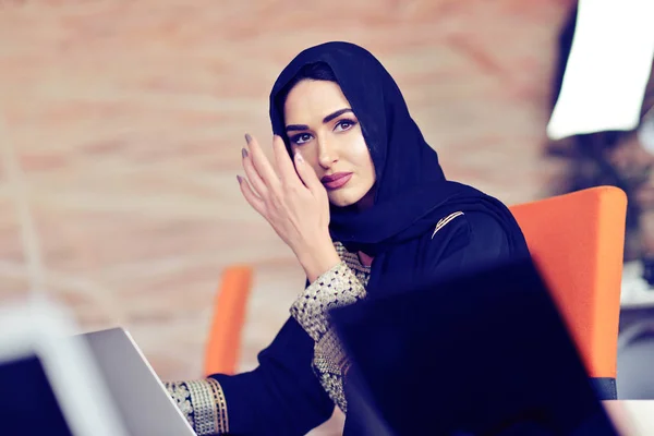 Мусульманская азиатка работает в офисе с ноутбуком — стоковое фото