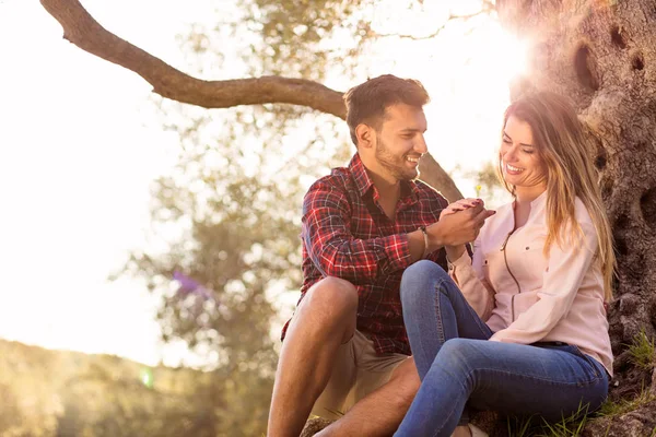 Joven hermosa pareja bajo el árbol en la hermosa naturaleza . — Foto de Stock