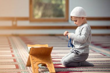Müslüman çocuk camide dua ediyor, küçük çocuk Tanrı'ya, barış ve sevgi Ramazan kutsal ay içinde dua ediyor.