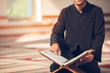 Dindar Müslüman adam caminin içinde dua ediyor.