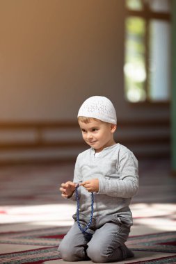 Müslüman çocuk camide dua ediyor, küçük çocuk Tanrı'ya, barış ve sevgi Ramazan kutsal ay içinde dua ediyor.