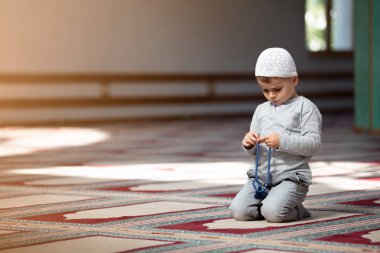 Müslüman çocuk camide dua ediyor, küçük çocuk Tanrı'ya, barış ve sevgi Ramazan kutsal ay içinde dua ediyor.