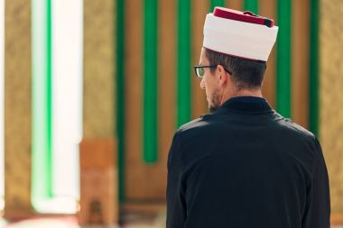 Dindar Müslüman adam caminin içinde dua ediyor.