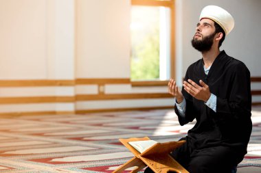 Dindar Müslüman adam caminin içinde dua ediyor.