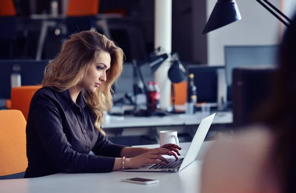 Portrait de jolie jeune femme d'affaires souriante assise sur le lieu de travail — Photo