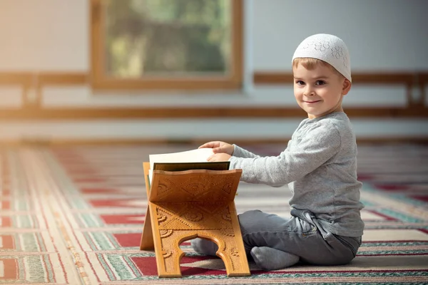 The Muslim child prays in the mosque, the little boy prays to God, Peace and love in the holy month of Ramadan.